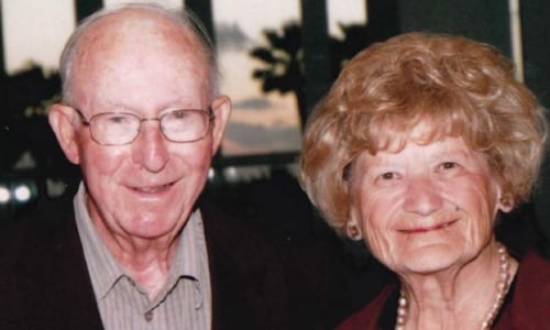 An older couple, smiling at the camera