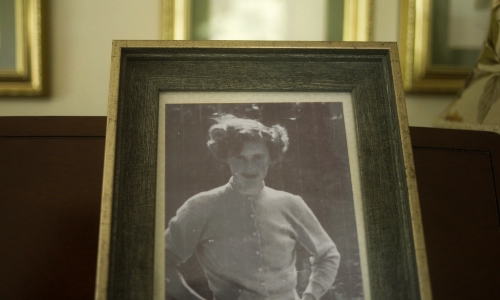 An old black-and-white framed photograph of a young woman